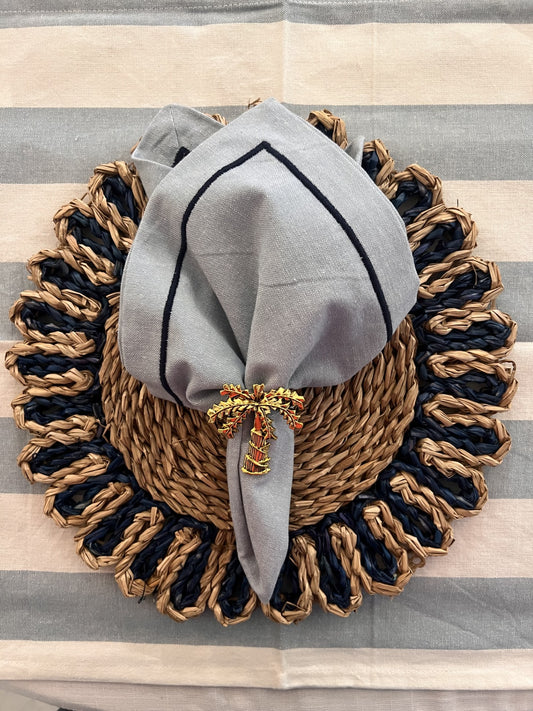 Blue cotton napkin with navy trim and navy woven placemat