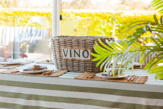 Olive green stripe tablecloth with seagrass woven placemats and vino bucket cooler
